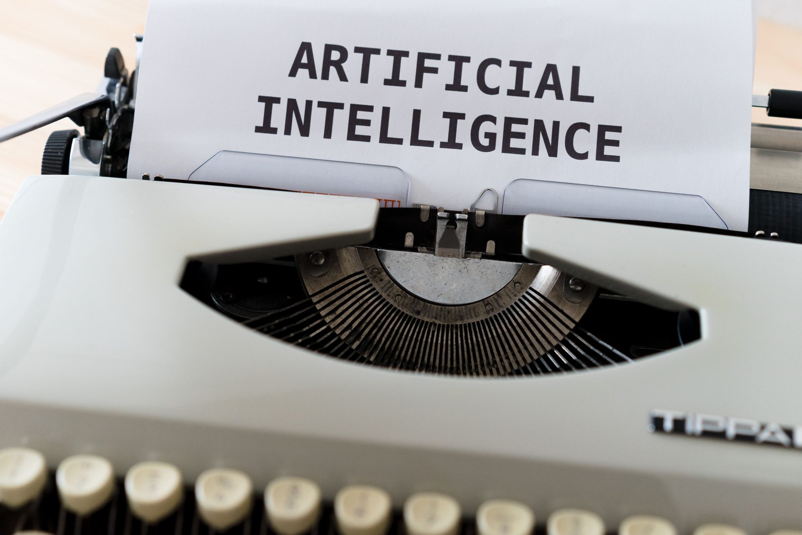 Vintage typewriter with the words artificial intelligence typed on paper, illustrating AI writing