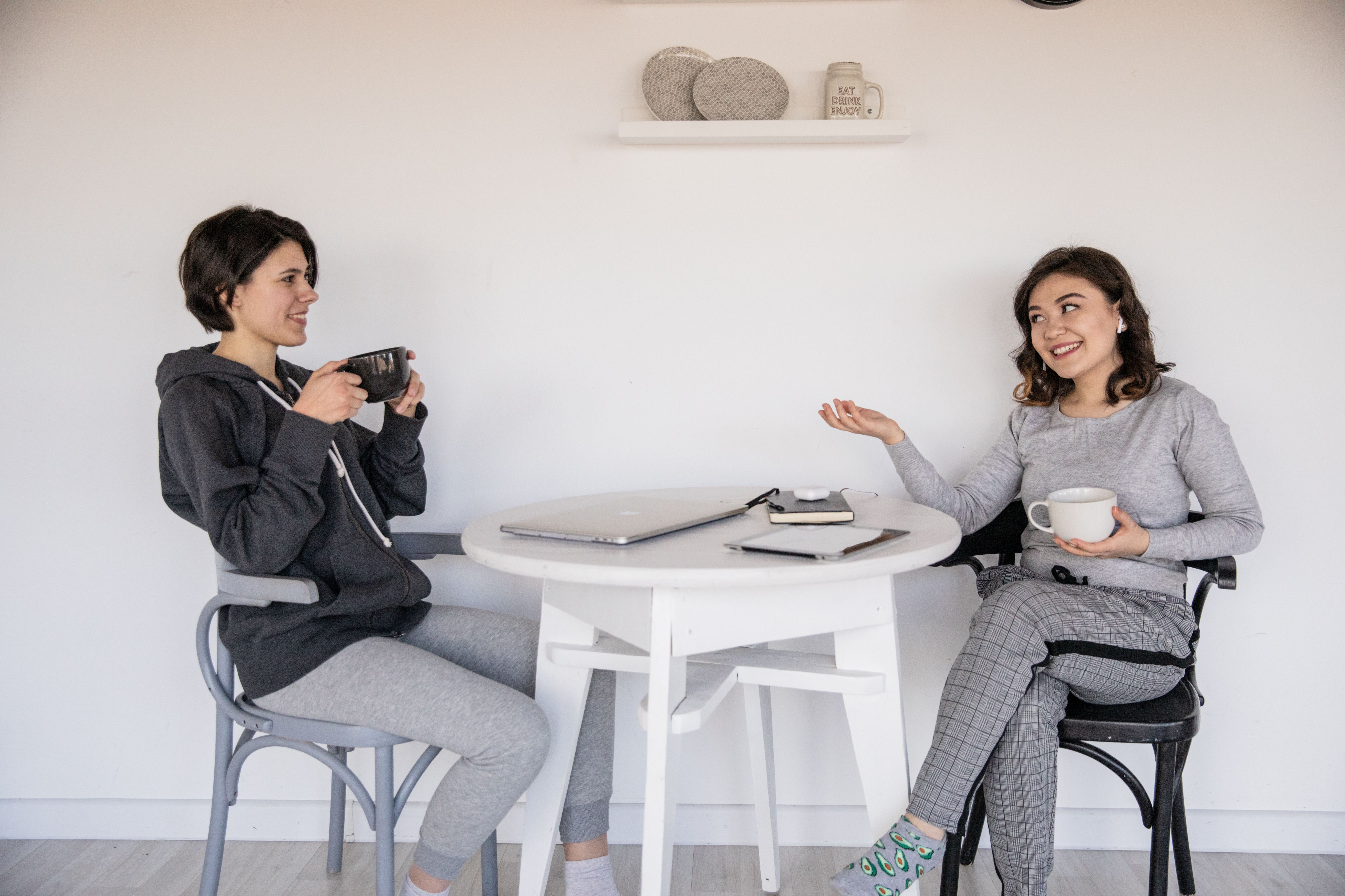 Two women chatting over coffee, showing the natural conversational tone of human writing