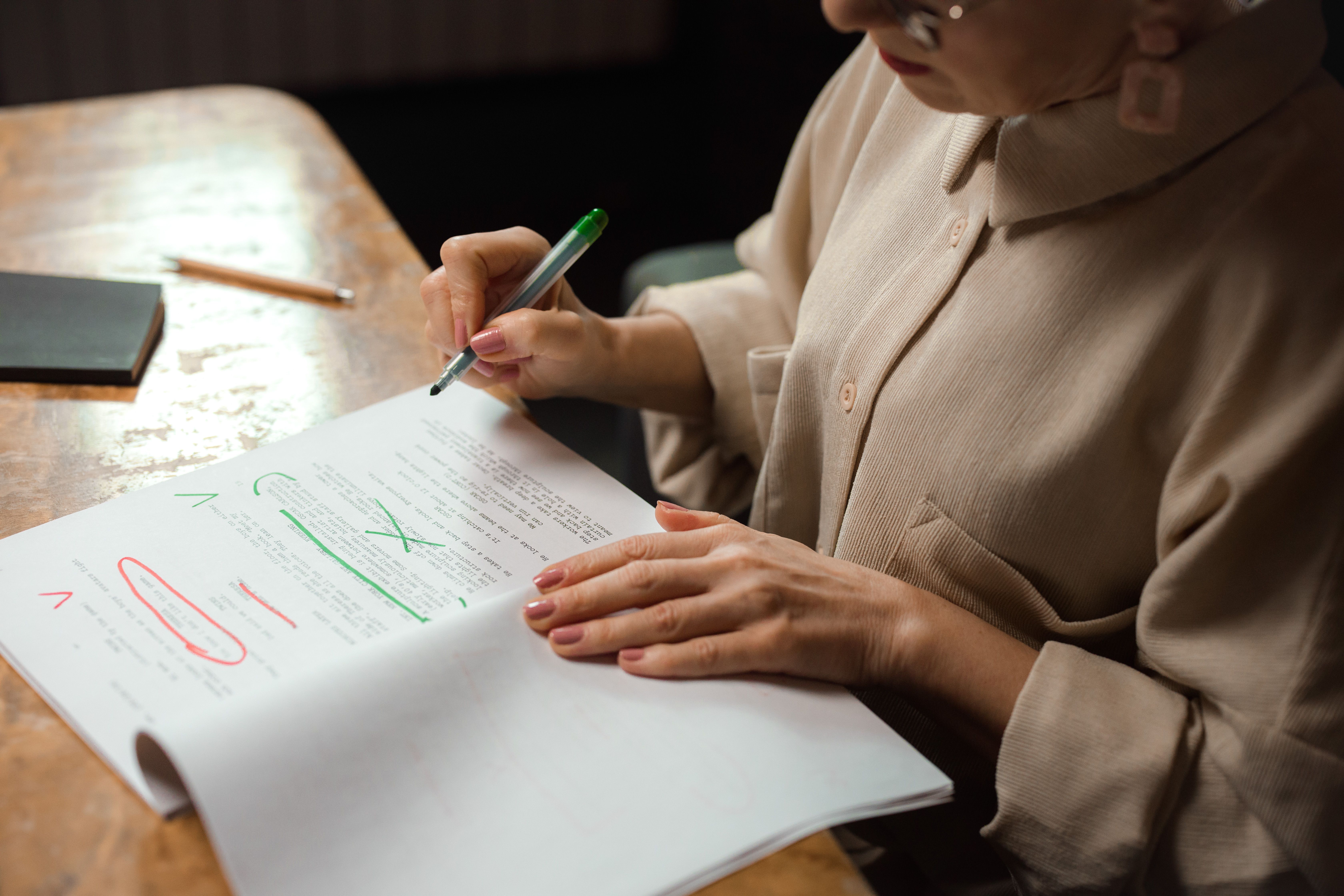 Writer editing a manuscript with a marker, revising AI-sounding text to sound more human